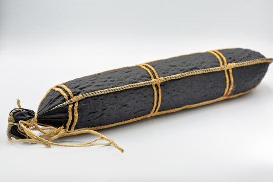 Traditional cured horse meat sausage in dark casing, closeup.
