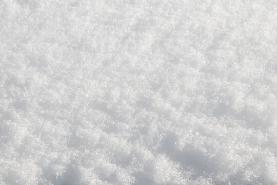 Close up texture of white snow with sparkling snowflakes