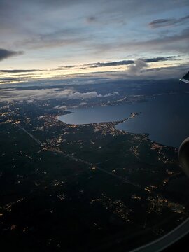 Coastal City and Curved Bay at Blue Hour Seen From an Airplane