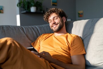 Fototapeta premium Smiling man relaxing on sofa with smartphone in bright living room for lifestyle background and wellness banner design