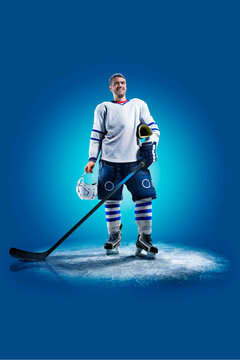 Hockey. Professional hockey player isolated on blue background. Hockey player in action. Hockey concept. Sport