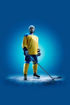 Hockey. Professional hockey player isolated on blue background. Hockey player in action. Hockey concept. Sport