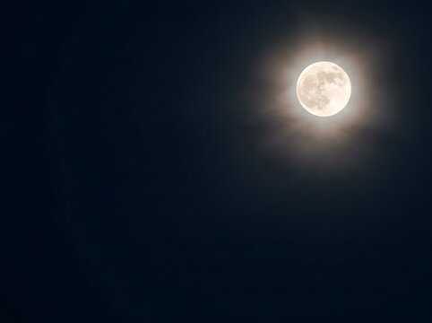 Glowing Full Moon in Dark Night Sky with Bright Lunar Corona Effect