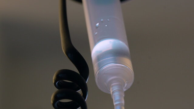 Intravenous therapy fluid moving through drip chamber in clinical environment, symbolizing precise treatment delivery, healthcare monitoring, patient recovery