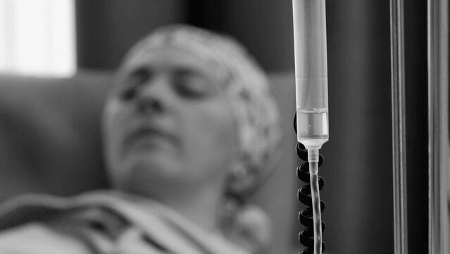 Monochrome intravenous drip and female patient during medical treatment, emphasizing healthcare recovery, serious illness, endurance, resilience and the emotional reality of healing