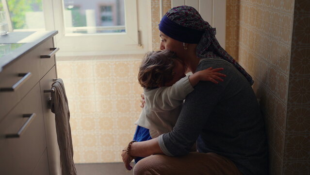 Mother embracing upset toddler while offering comfort and emotional support, authentic family lifestyle scene highlighting secure attachment, affection and parental care
