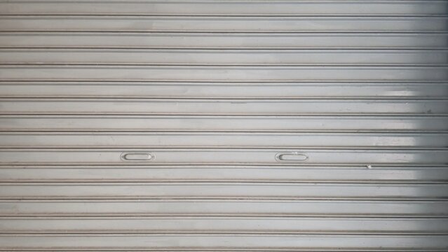 Rolling door. Steel shutter door of a warehouse. The shutters are gray metal. Steel rolling shutter background. Silver metal rolling shutter background. Background images and texture images.