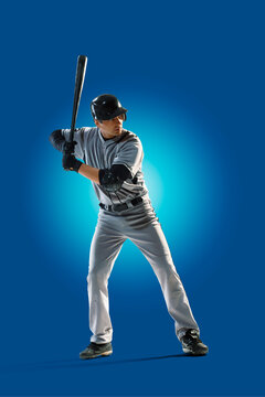 Baseball. Professional baseball player isolated on blue background. Baseball player in action