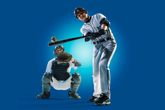 Baseball. Professional baseball player isolated on blue background. Baseball player in action