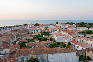 Saint-Martin-de-Ré au coucher du soleil offre un spectacle magique, où la lumière dorée illumine les fortifications de Vauban, le vieux port et les reflets paisibles de l'océan. © bru greg