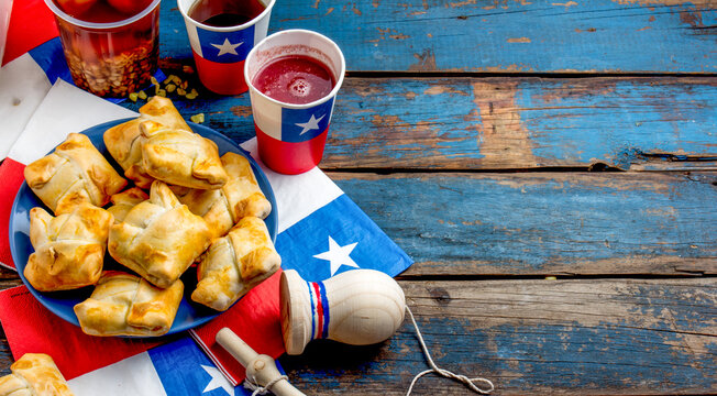 Chilean independence day concept. fiestas patrias. Chilean typical dish and drink on independence day party, 18 september. Mini empanadas, wine with toasted flour, chicha and tipical play emboque
