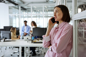 Obraz premium Diverse business team talking phone during a collaborative office meeting