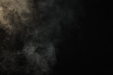 Fototapeta premium Beautiful smoke in light on dark background, space for text