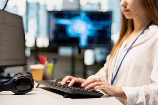 Close-up view of a female engineer writing AI code and developing applications on an office computer during a startup internship, typing and debugging with artificial intelligence.