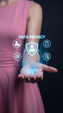A person's open palm displays a glowing hologram representing data privacy. The hologram features a shield with a person icon at its center.