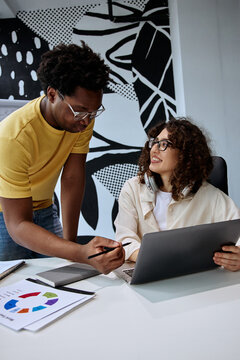 Two coworkers discussing work during a collaborative office meeting