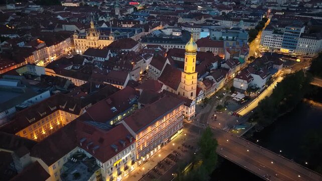 Aerial night view of Graz old town, Franziskanerkirche and Mur river, Austria
