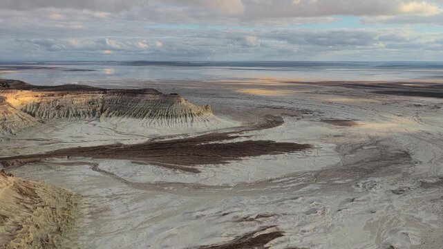 Aerial view of Bozjyra cliffs and vast desert landscape under a cloudy sky in Aktau, Mangystau Region, Kazakhstan.