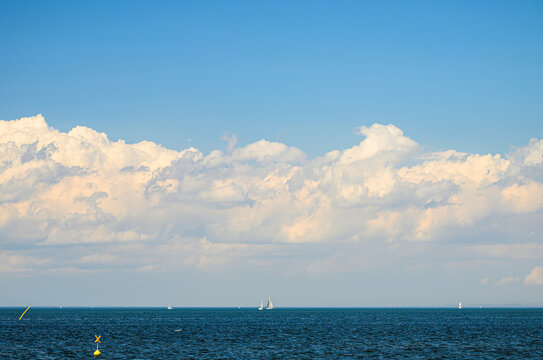 Expansive summer clouds above calm Scandinavian coastal waters.