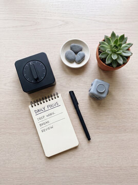 Flat lay of focus tools with timer notebook fidget cube and succulent