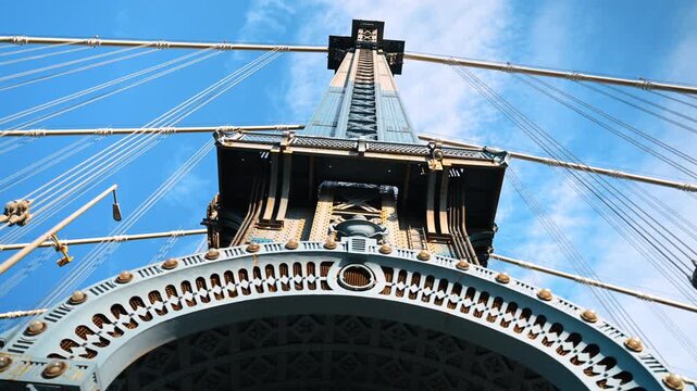 Observing decor, elements and details at the Manhattan Bridge. Low angle view at the structure against blue sky.