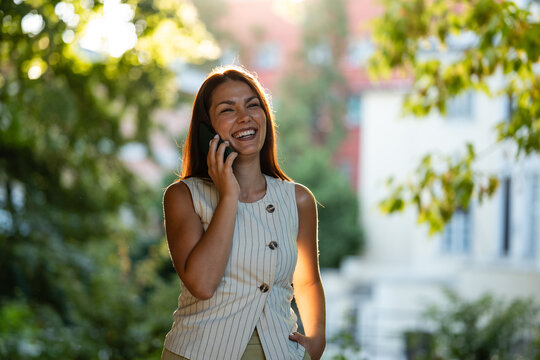 Happy woman talking on phone outdoors enjoying communication