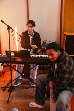 Two young musicians playing instruments in a creative music studio