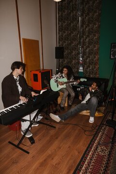 Group of young musicians playing music in a creative music studio
