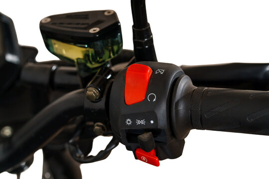 Close up of motorcycle handlebar with red engine kill switch and control panel on white background..