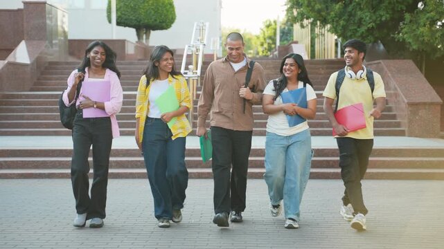 Group of happy indian students walking together on campus