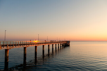 Fototapeta premium People watching sunset from sea pier