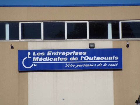 Gatineau, Quebec, Canada &ndash; June 21, 2026: A blue business sign reading "Les Entreprises M&eacute;dicales de l'Outaouais" mounted on the exterior wall of a commercial building on Rue Saint-Antoine.
