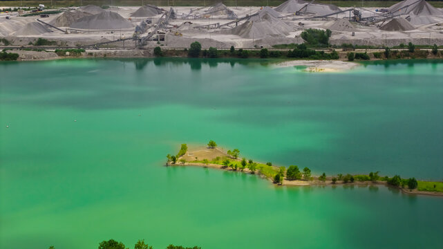 Quarry lake with turquoise water and working gravel pit