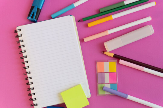 Creative stationery layout on vibrant pink surface