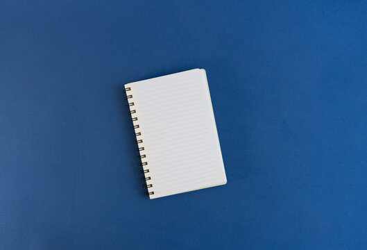 Blank notebook on blue background, perfect for notes, sketches, or brainstorming