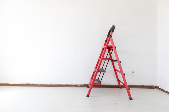 A red ladder in an empty room