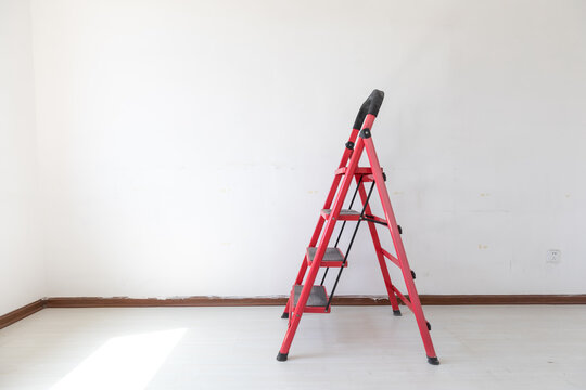 A red ladder in an empty room