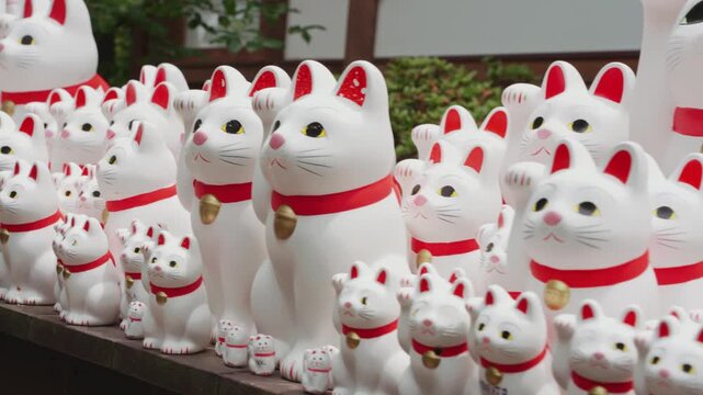 Lucky cute Maneki Neko cat figurines at Gotokuji Temple, ideal for themes of Japanese culture, travel, spirituality, tourism, good fortune, tradition, and iconic landmarks.