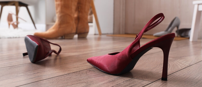 Red high heel shoes on a wooden floor with Other footwear in the background, fashion and elegance