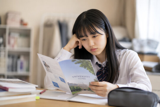 大学案内を読みながら進路を考える女子高校生