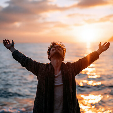 夕暮れの海を背景に両手を広げ自由を謳歌する若者の力強いシルエット