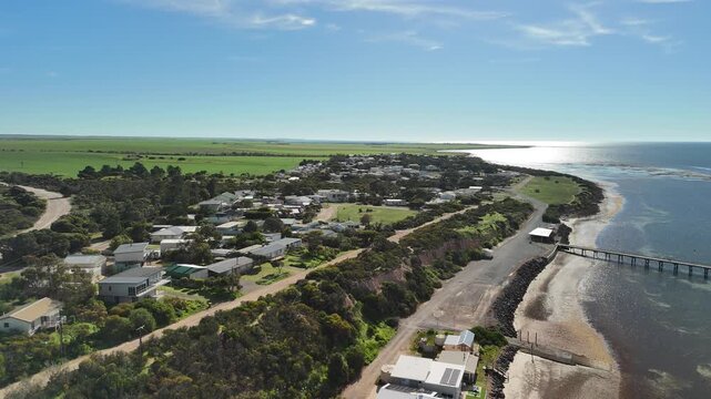 Port Julia, Yorke Peninsula, South Australia &ndash; 4K aerial drone view of jetty, sheltered beach, limestone cliffs, coastal township and Gulf St Vincent, beachfront holiday homes, surrounding farmland.
