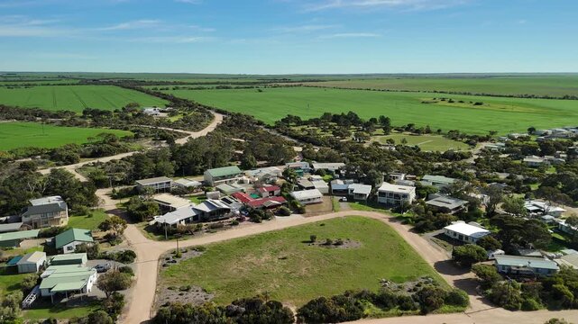 Port Julia, Yorke Peninsula, South Australia &ndash; 4K aerial drone view of jetty, sheltered beach, limestone cliffs, coastal township and Gulf St Vincent, beachfront holiday homes, surrounding farmland.
