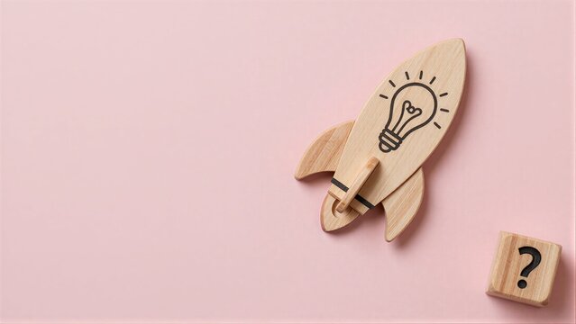 Wooden rocket with lightbulb, beside a question block on pink background.