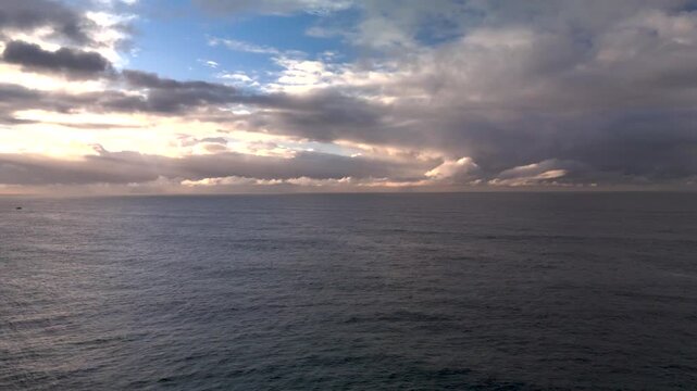 Stormy sunrise from Bronte Beach in Sydney, Australia. Camera pans from right to left over the ocean and horizon wit dramatic sky and reflection.