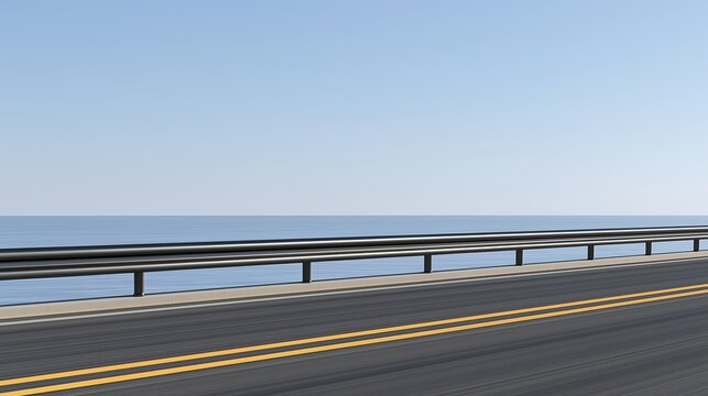 Empty coastal asphalt road with double yellow lines and black metal guardrail next to calm blue sea under clear light blue sky