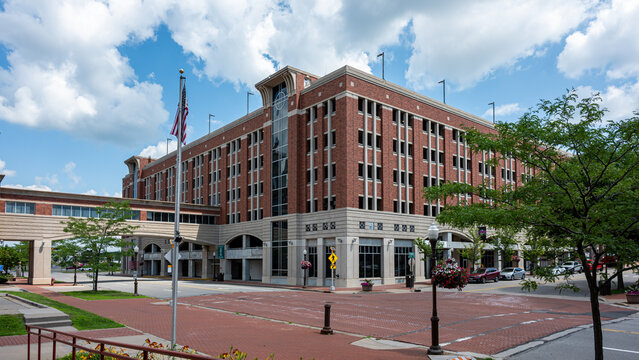 WAUSAU, WI - JUL 11 2026 A large brick parking ramp structure sits at a downtown intersection connected with a skybridge under a blue sky.