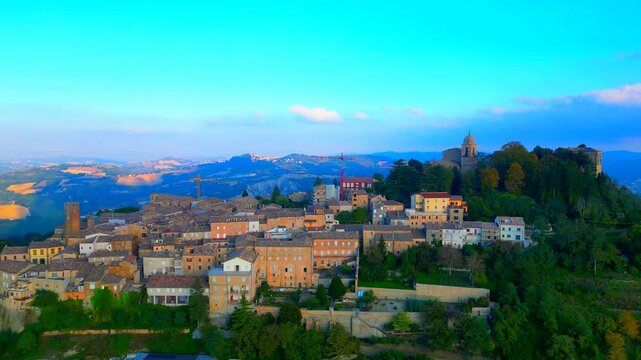 SANTA VITTORIA IN MATENANO, ITALY - OCTOBER 10, 2025: Aerial pedestal up pullback shot of the town centre. Offering timeless views of the surrounding mountains, and an authentic Italian lifestyle