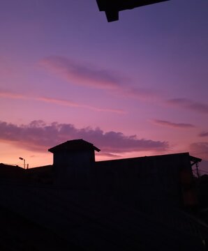 The sun rises behind the house 