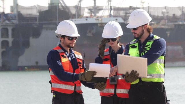 Team architects and engineers held meetings discussed ideas and worked outdoors on laptops inspecting construction sites such as ports and shipyards glasses safety helmets while working field.